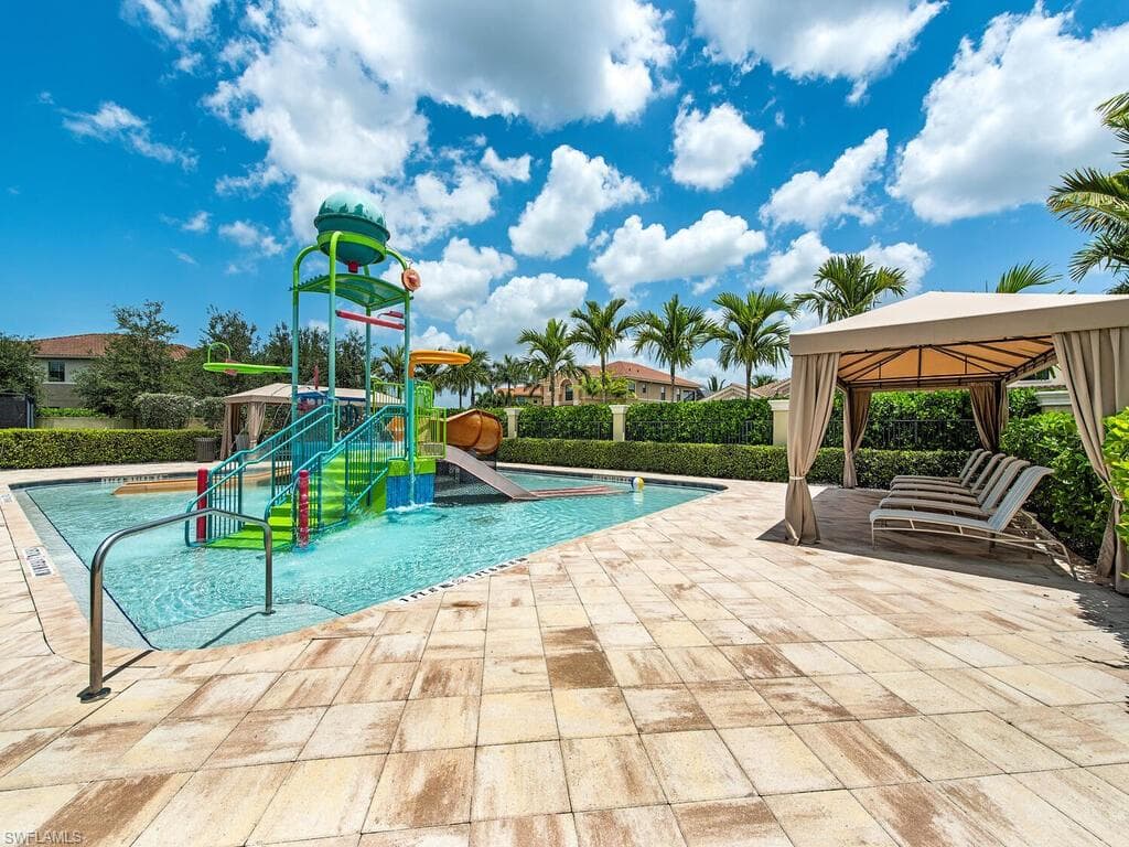 View of pool with a gazebo, a patio area, a playground, and a water slide