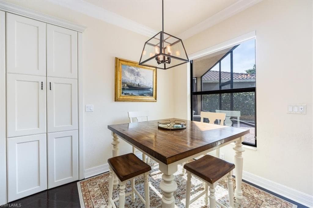 Dining space with ornamental molding and a chandelier