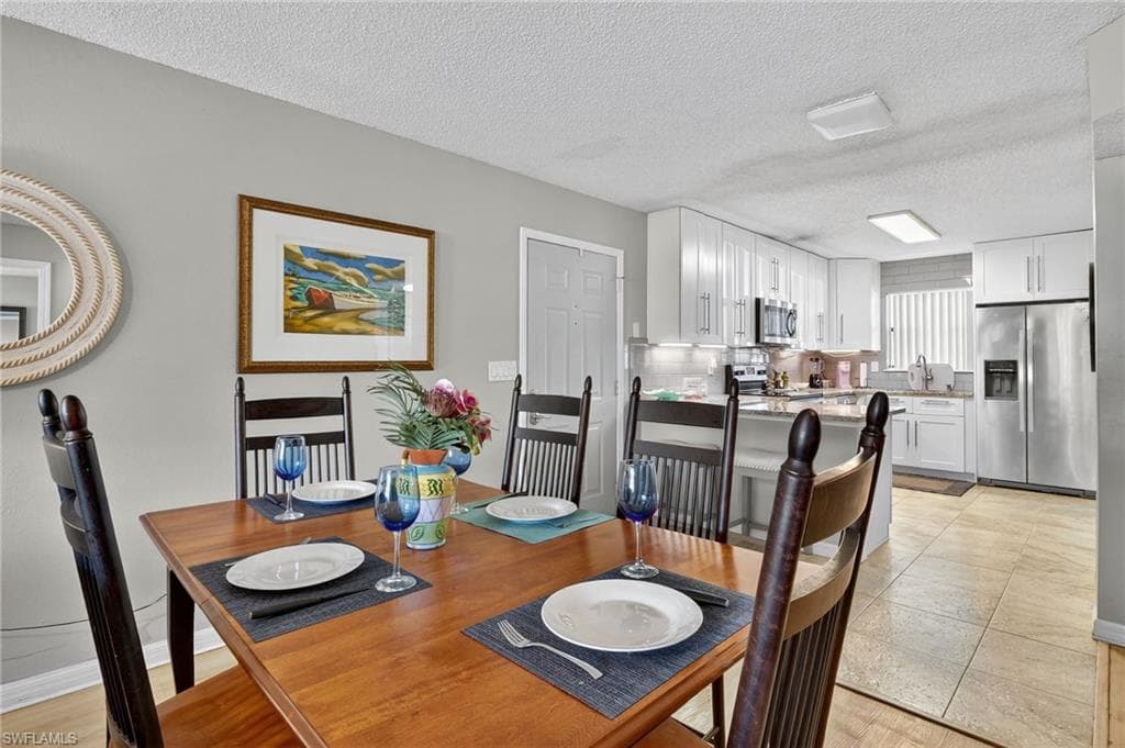 Dining area featuring a textured ceiling and light tile patterned floors