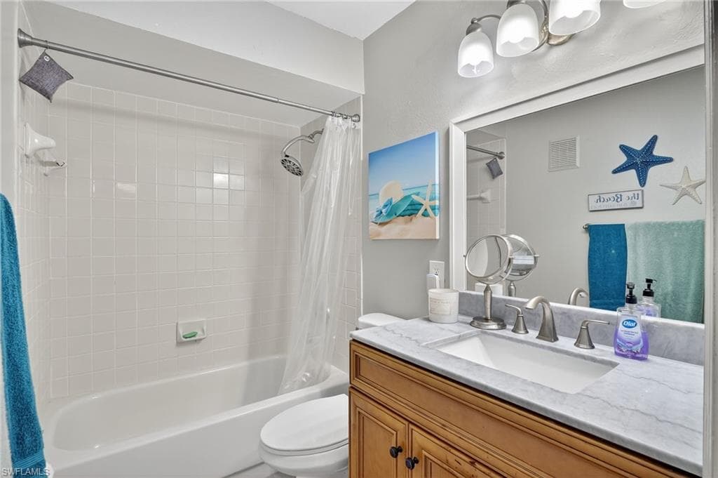 Guest Bathroom featuring shower / bath combination with curtain and vanity