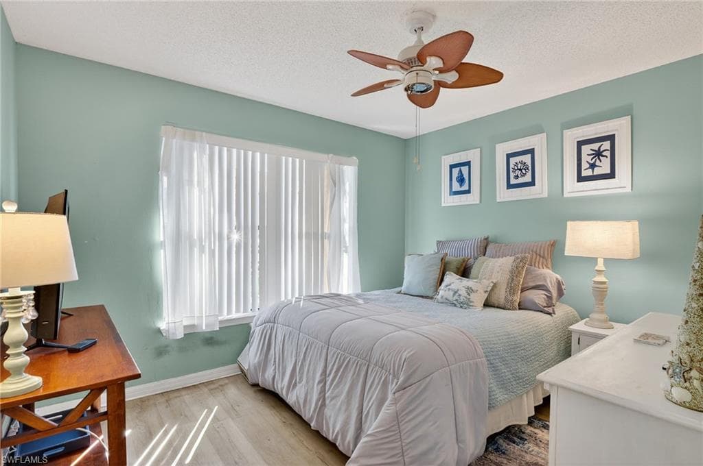Bedroom featuring wood finished floors, ceiling fan, and a textured ceiling