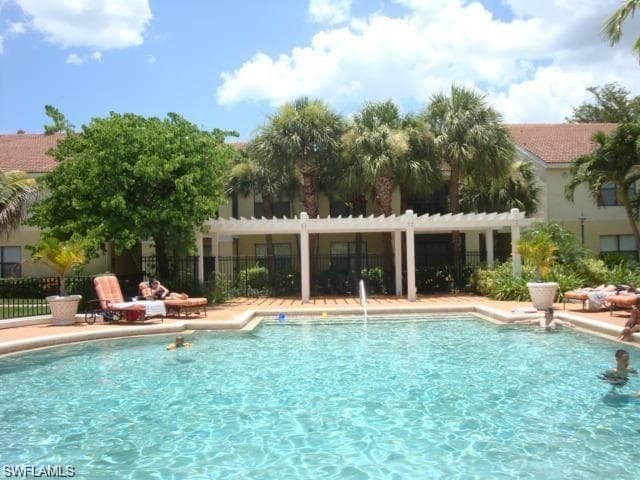 Community pool featuring a pergola and a patio area