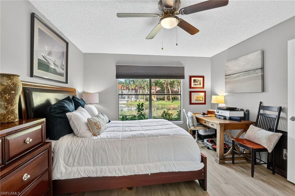 Bedroom featuring wood finished floors, a textured ceiling, and a ceiling fan