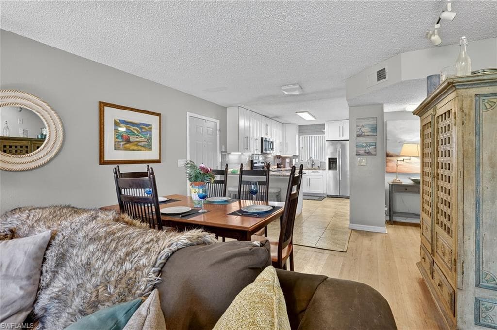 Dining area featuring a textured ceiling and light wood-style floors