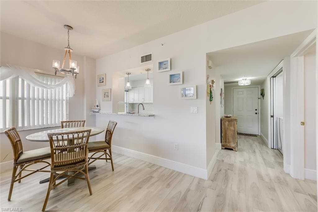 Dining room featuring light wood-type flooring and a chandelier