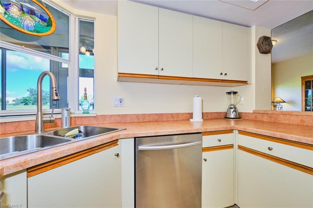 Kitchen includes dishwasher, light countertops, and white cabinets