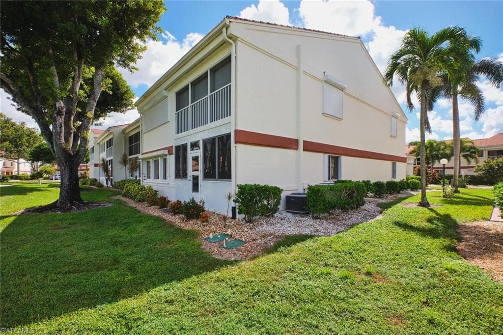 View of side of property with a yard and stucco siding