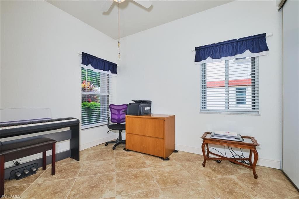 Office area featuring light tile patterned floors and a ceiling fan