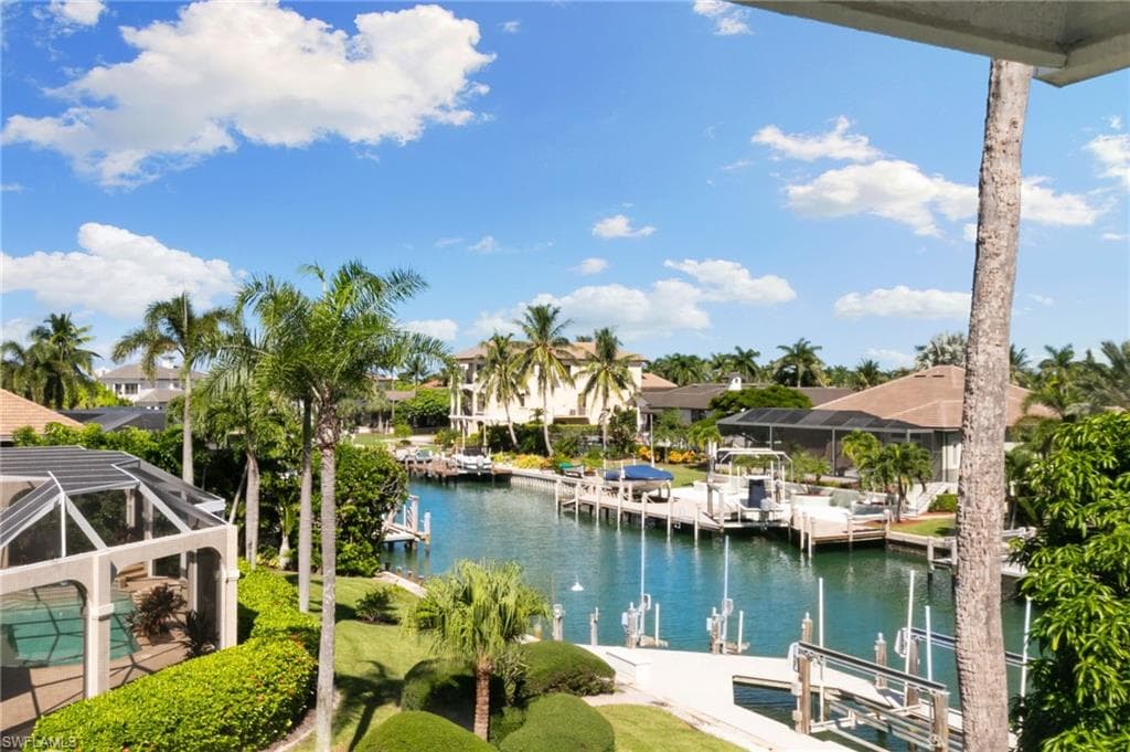 Dock area featuring boat lift, a water view, a sunroom, and glass enclosure