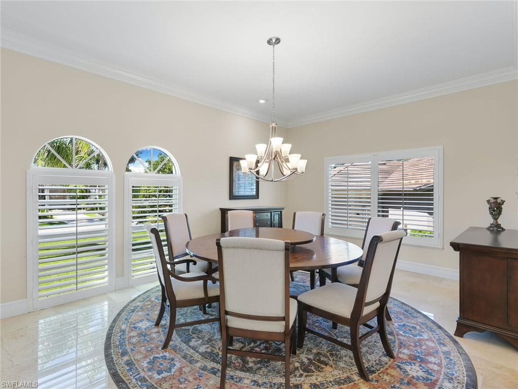 Dining room featuring crown molding and a chandelier