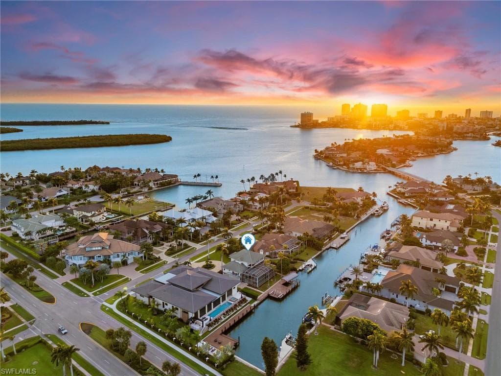 Aerial view at dusk of a water view, a residential view, and a view of city