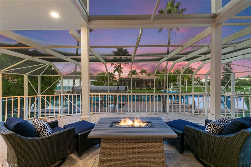Patio terrace at dusk with a patio area, glass enclosure, an outdoor pool, and an outdoor living space