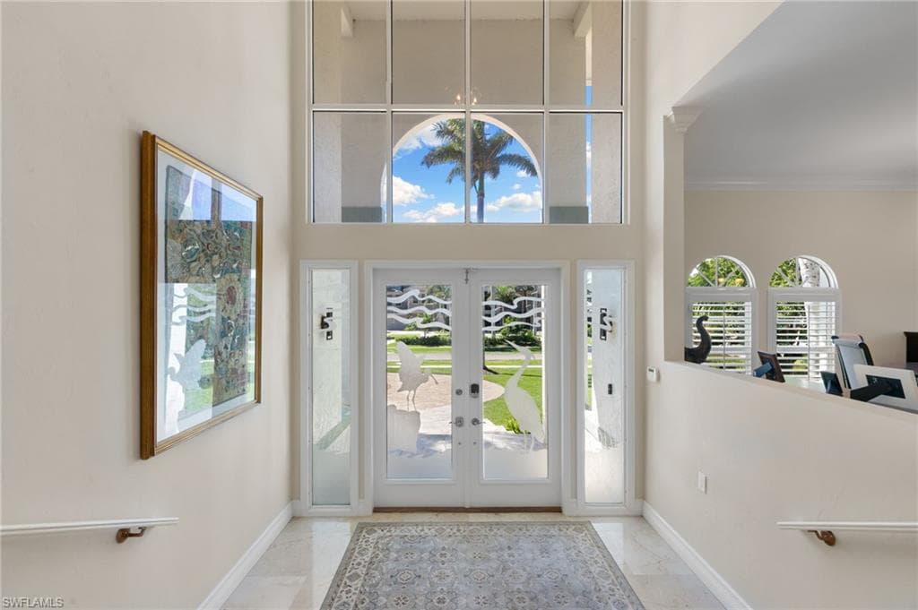 Foyer entrance featuring french doors and light marble finish floors