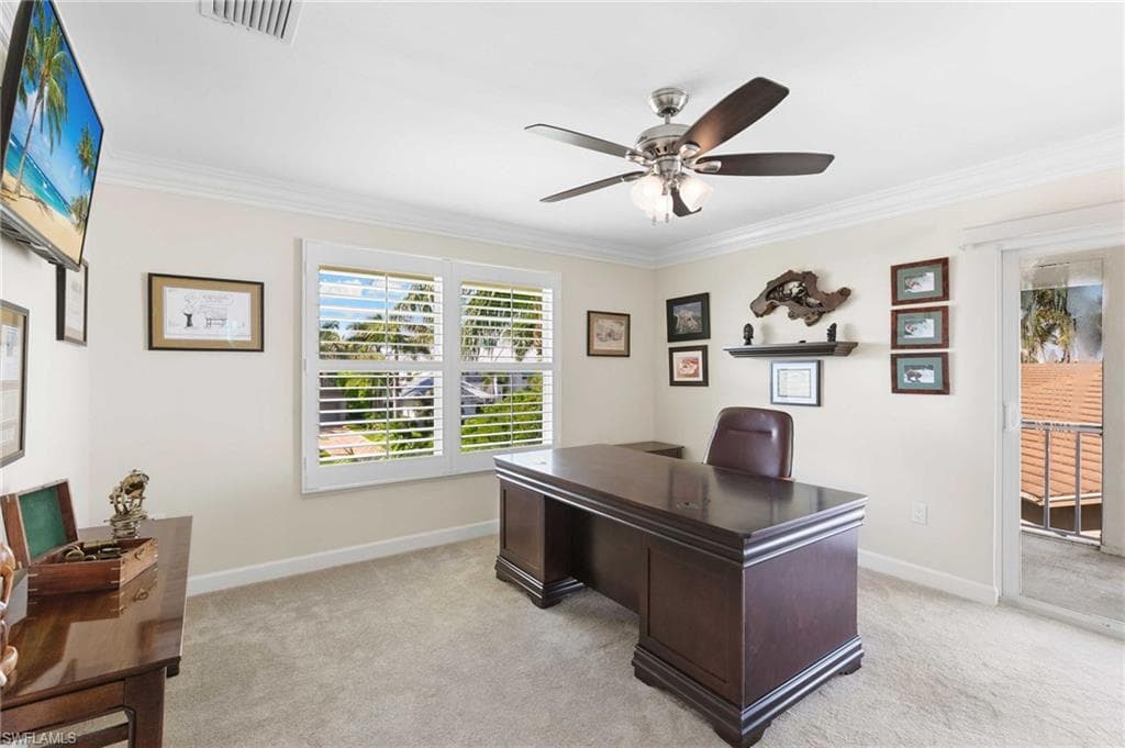 Home office with light colored carpet, crown molding, and a ceiling fan