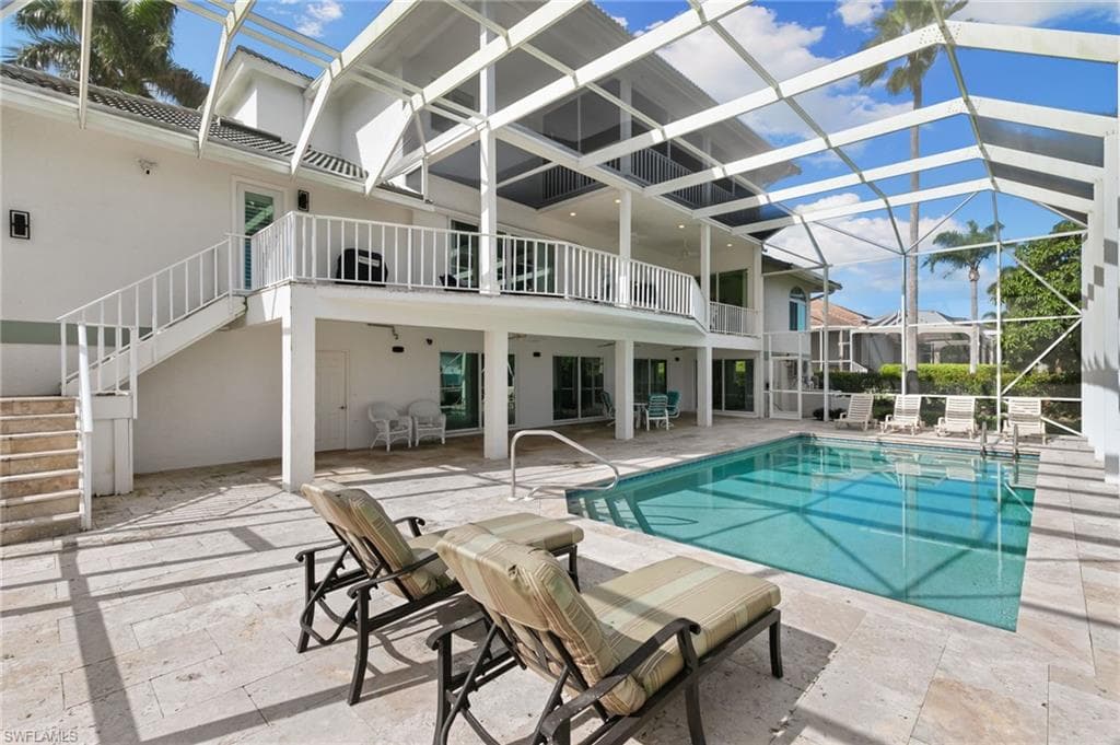 Outdoor pool with a lanai, a patio area, stairs, and a sunroom