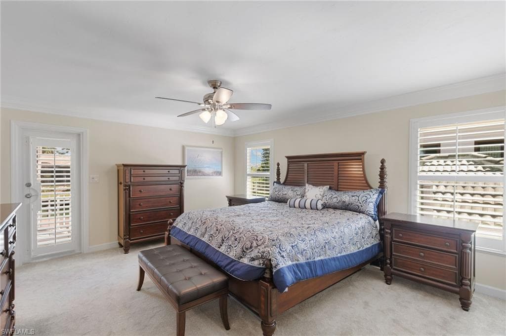Bedroom with light colored carpet, crown molding, access to exterior, and ceiling fan