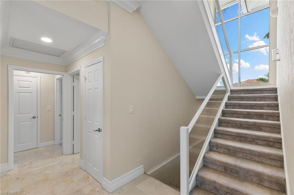Stairs with crown molding and attic access