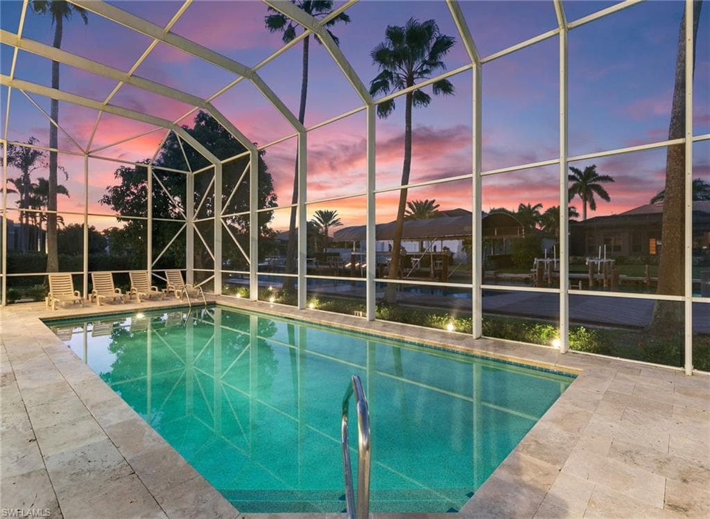 Swimming pool featuring a water view, a lanai, a sunroom, and a patio area