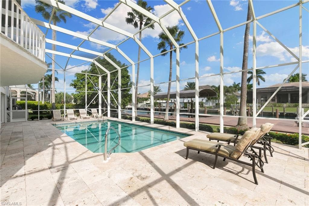 Outdoor pool featuring a sunroom, a patio, and a lanai