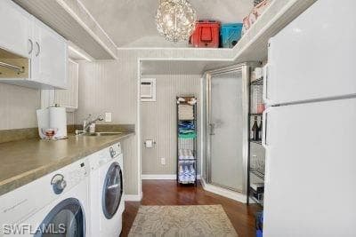 Laundry area with dark wood-style floors, a chandelier, and separate washer and dryer