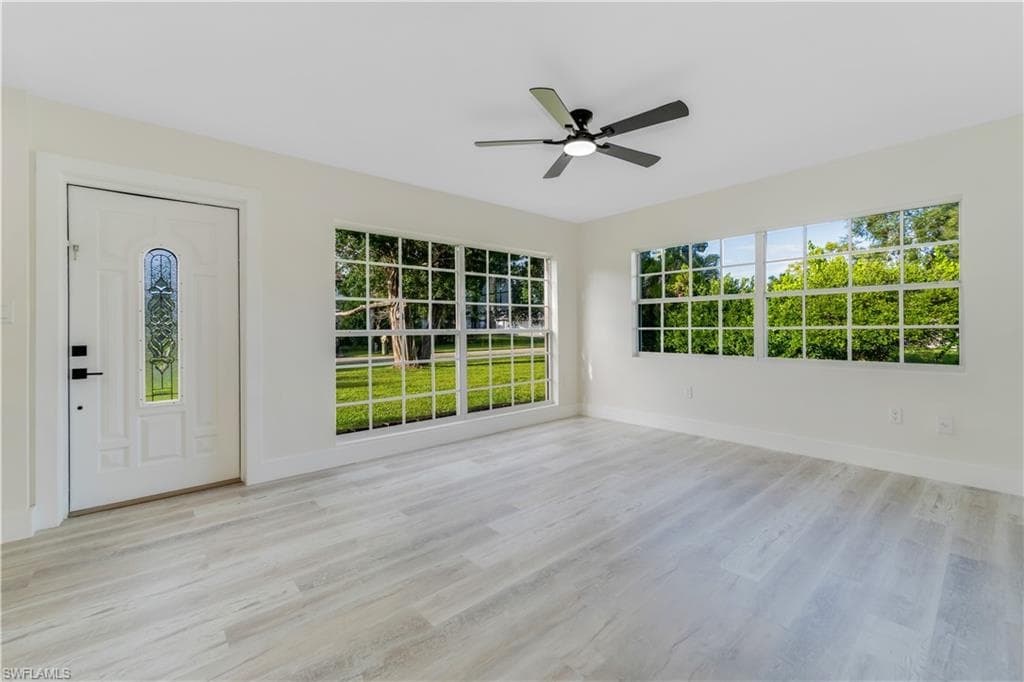 Entrance foyer with light wood-style flooring and a ceiling fan
