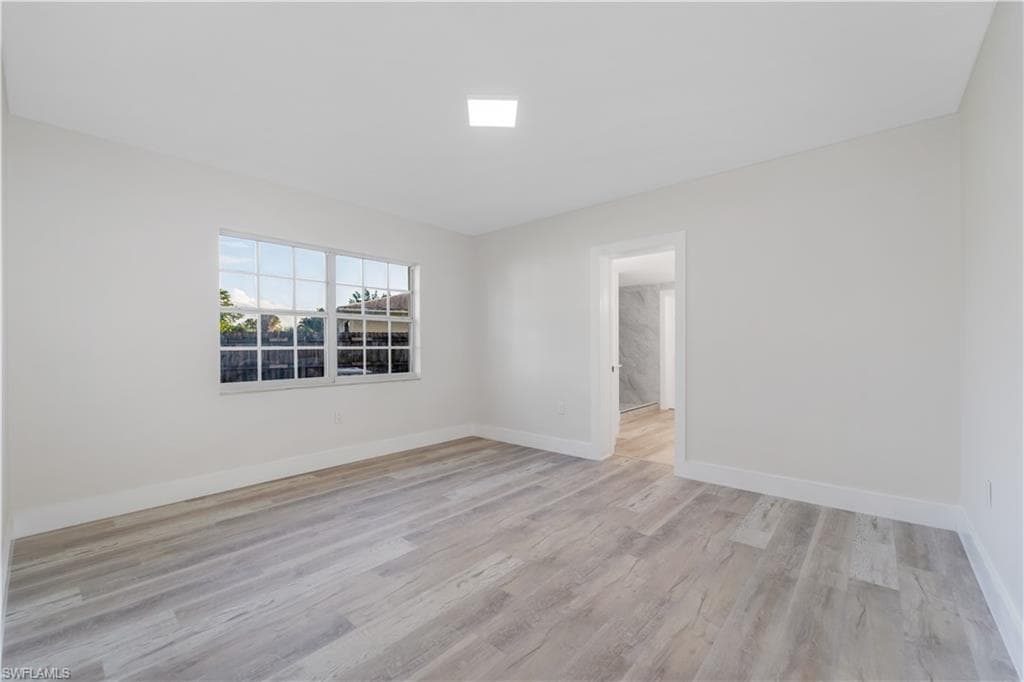 Unfurnished room featuring light wood-style flooring and baseboards