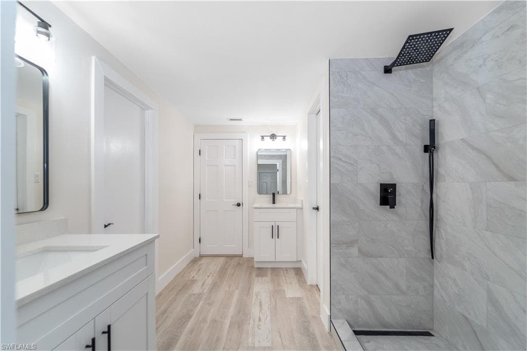 Hallway with tile walls and light wood-style flooring