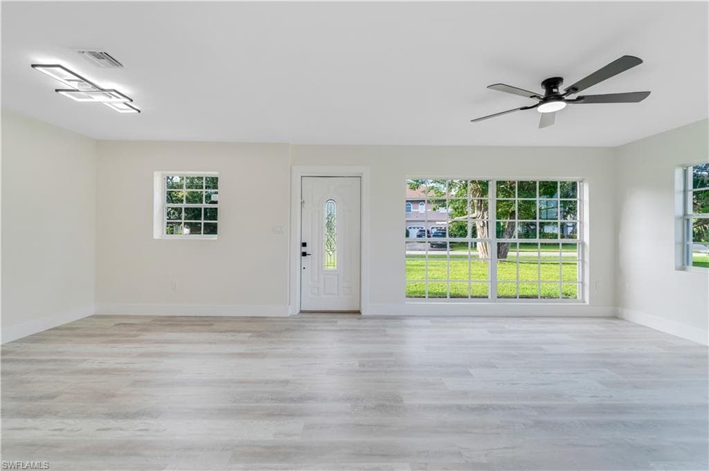 Single story home with asphalt driveway, an attached garage, a front yard, and brick siding