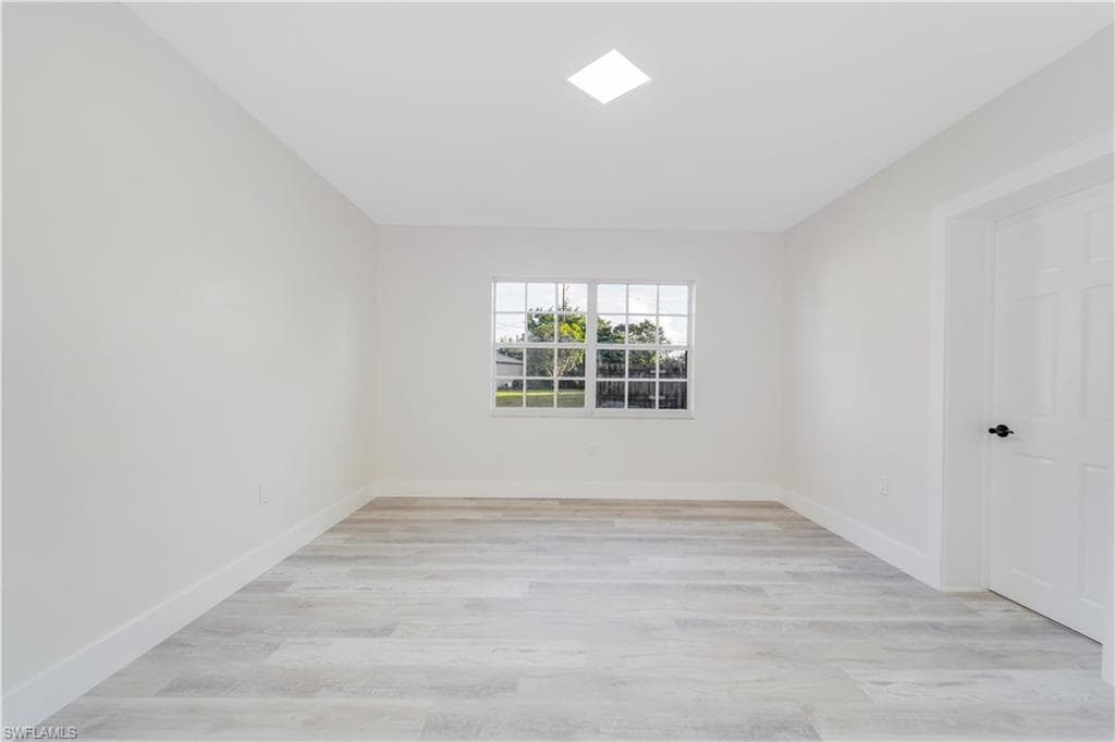 Unfurnished room featuring light wood-type flooring and baseboards