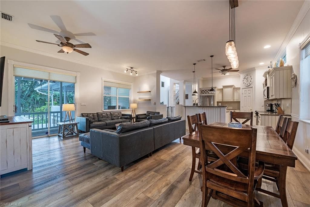 Dining/Living area with a ceiling fan, ornamental molding, and wood finished floors