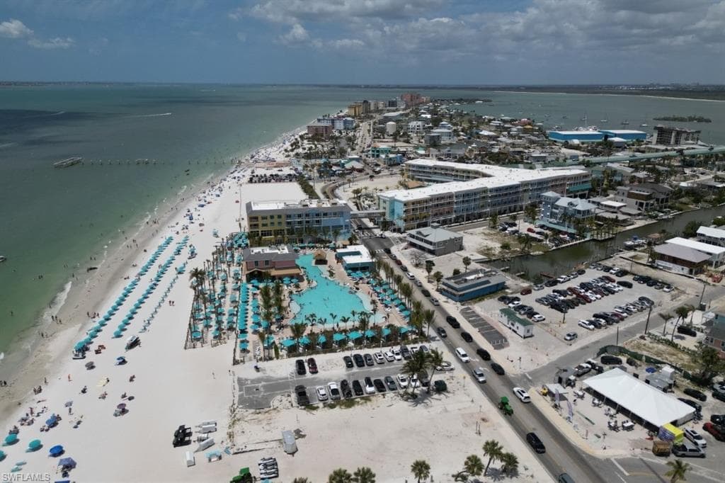 Aerial view of property and surrounding area with expansive coastline and nearby urban area