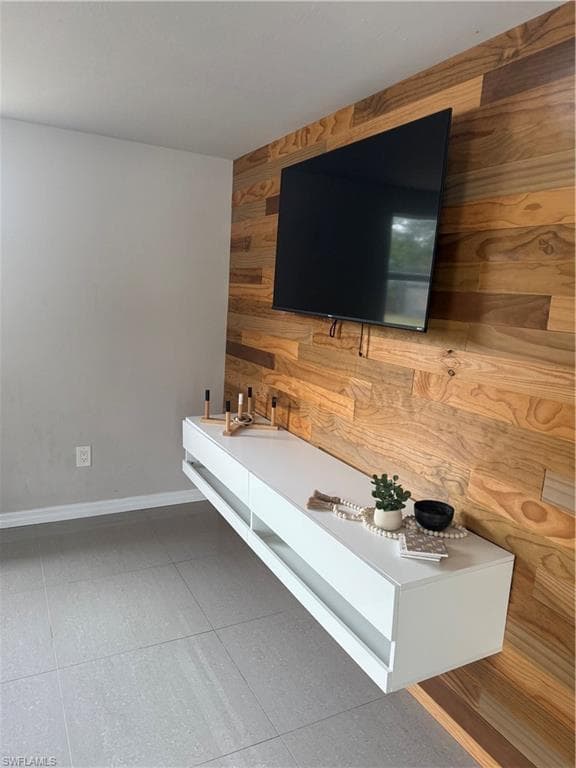 Unfurnished living room featuring wood walls