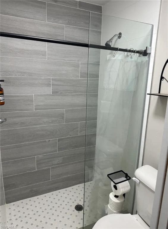 Bathroom featuring toilet and a shower with shower curtain