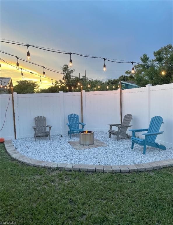 Yard at dusk featuring a fire pit