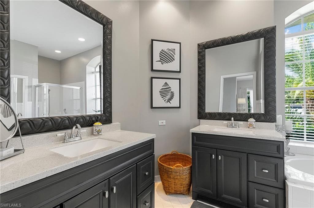 Bathroom with tile patterned floors, vanity, plus walk in shower, and a healthy amount of sunlight