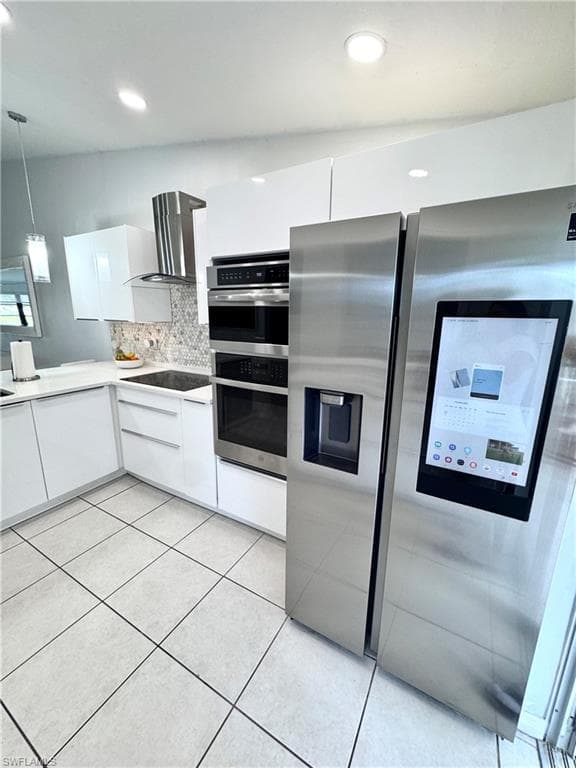 Kitchen featuring white cabinetry, stainless steel appliances, decorative backsplash, pendant lighting, and modern cabinets