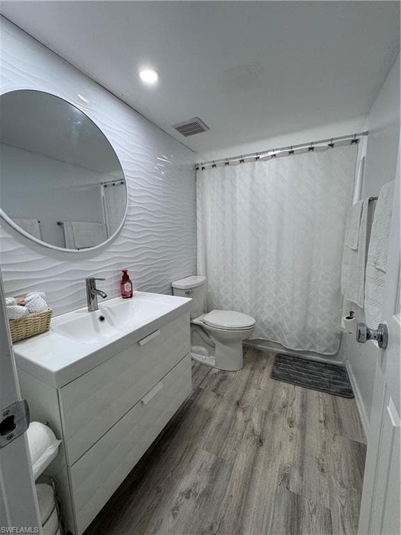 Bathroom featuring vanity, light wood-type flooring, shower / bath combination with curtain, and recessed lighting