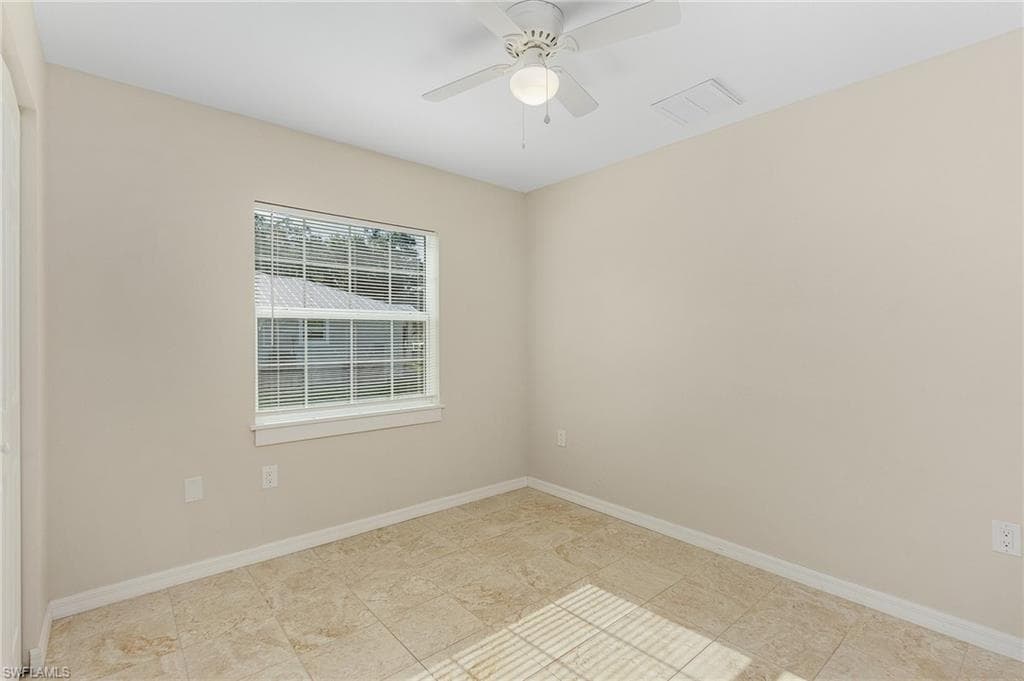 Spare room featuring baseboards and a ceiling fan