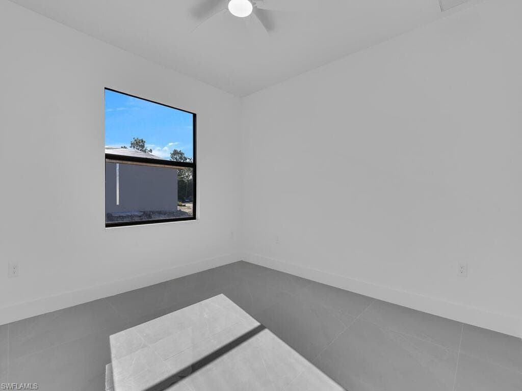 Empty room featuring tile patterned flooring and ceiling fan