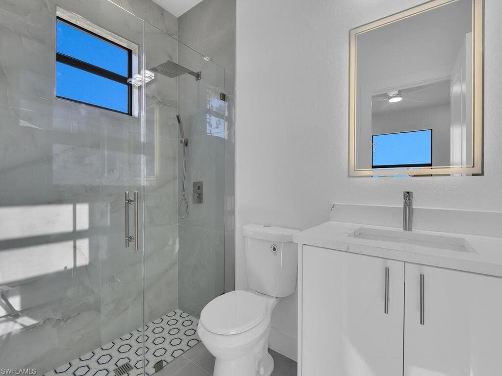 Bathroom with vanity, a marble finish shower, and tile patterned floors