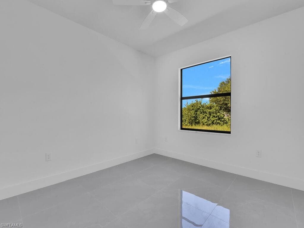 Empty room featuring baseboards and ceiling fan