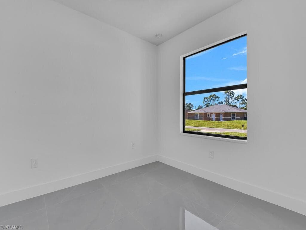 Empty room featuring baseboards and tile patterned flooring