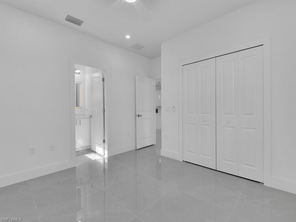 Unfurnished bedroom featuring light tile patterned floors, a closet, and recessed lighting