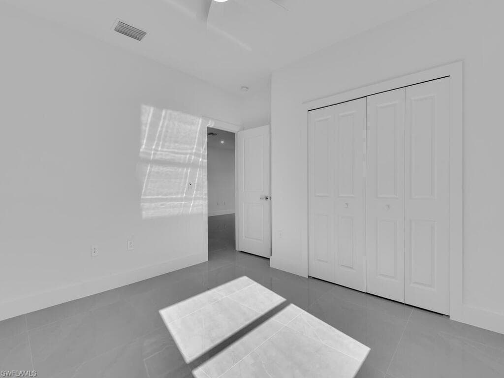 Unfurnished bedroom featuring tile patterned flooring and a closet