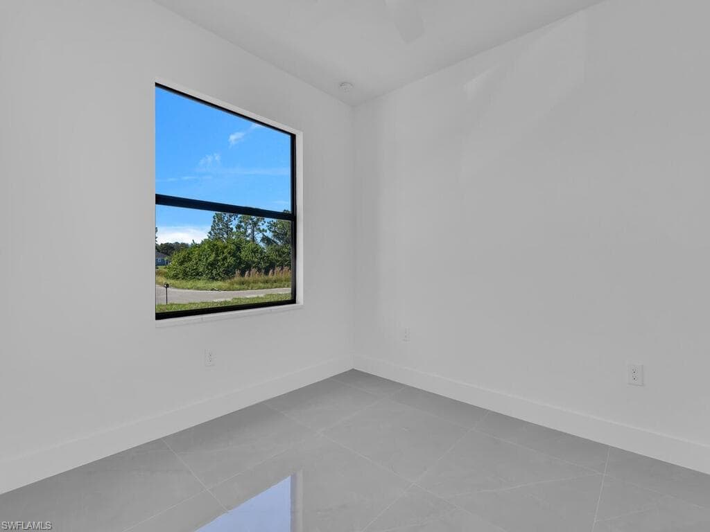 Spare room featuring baseboards and light tile patterned flooring