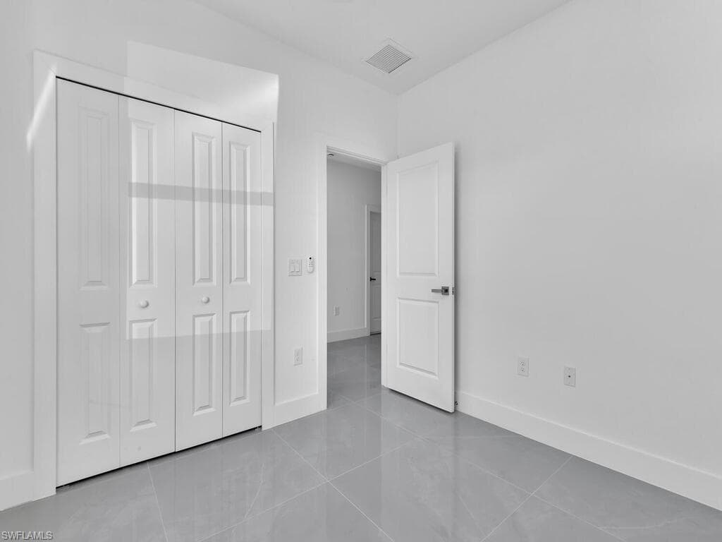 Unfurnished bedroom with tile patterned floors and a closet