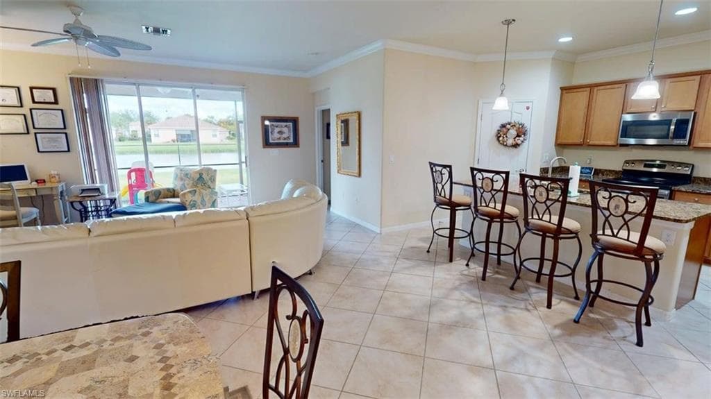 Living room with ornamental molding, light tile patterned flooring, ceiling fan, and recessed lighting