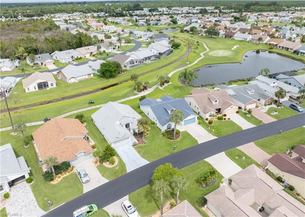 Home (blue roof) with view of golf course and pond in back.