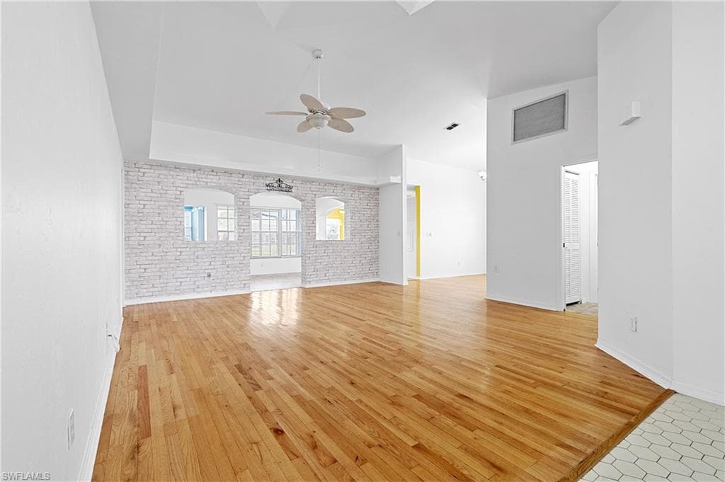 Looking in from front entrance into high ceiling great/family room into second family room.