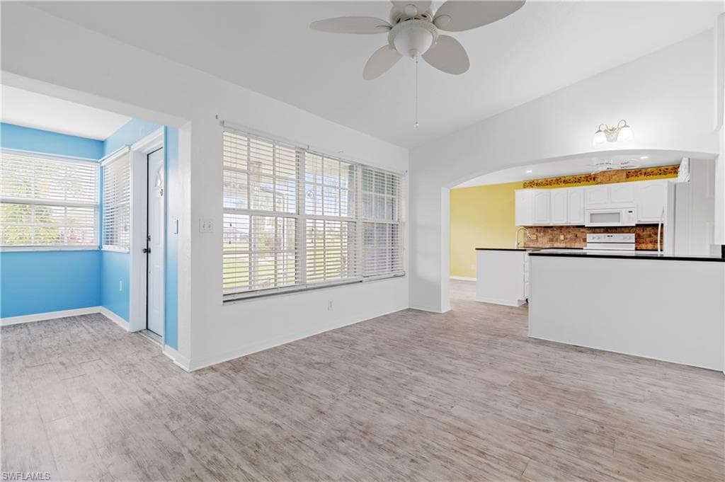 Family room / living room looking towards kitchen and screened in porch in back - overlooking golf course and pond.